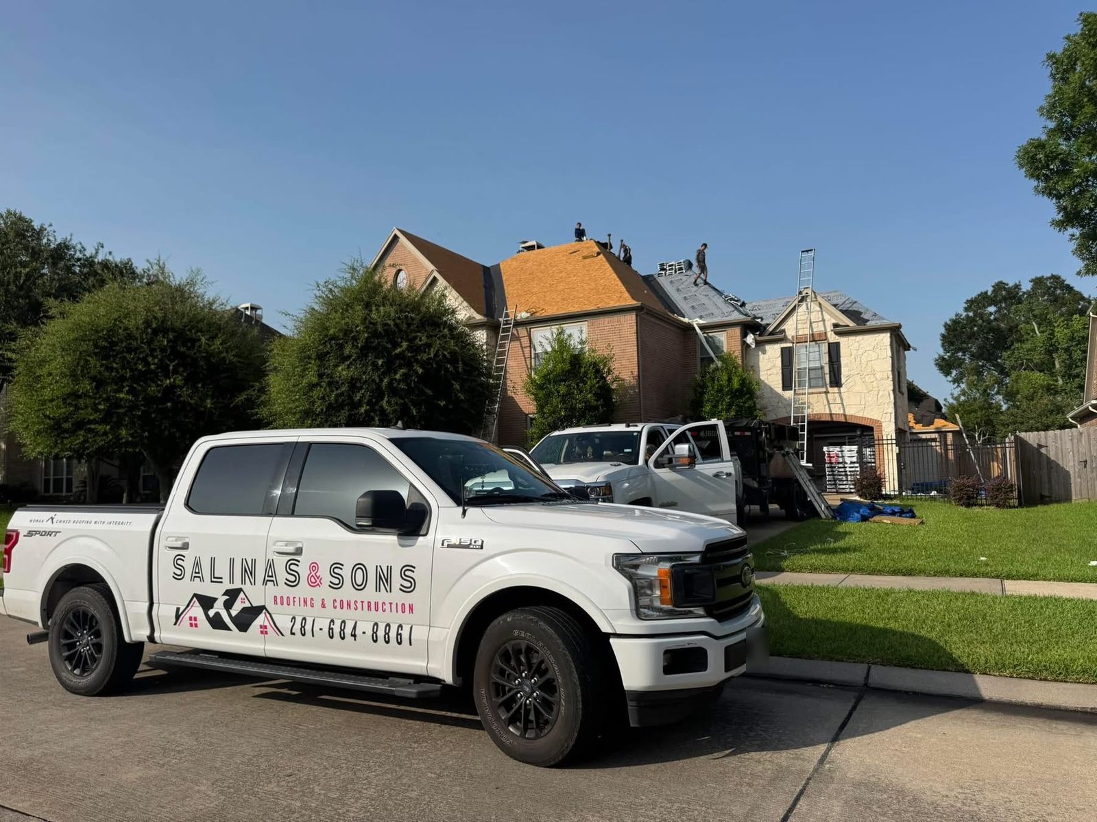 Salinas and Sons truck parked outside a two-story Friendswood home while the crew replaces the roof