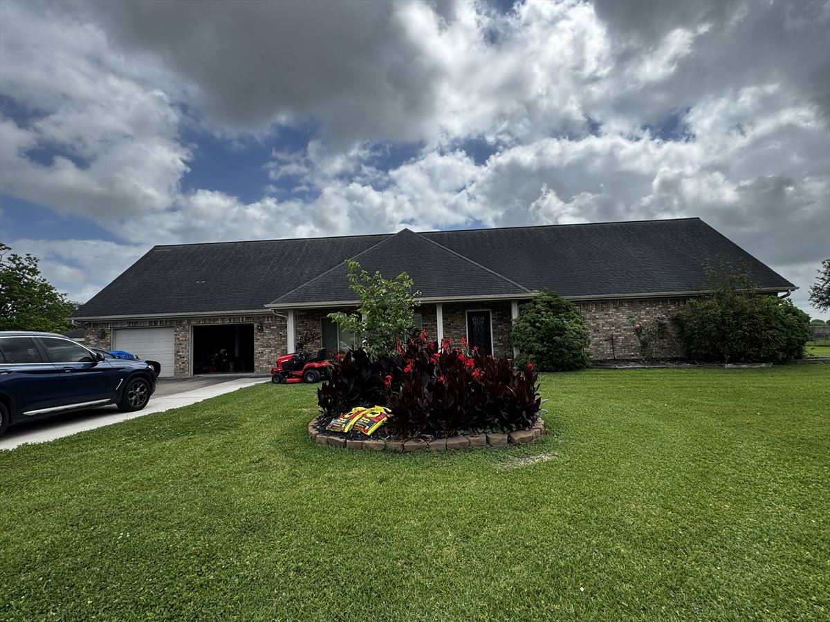Single-story brick home with its original dark, weathered shingle roof before replacement