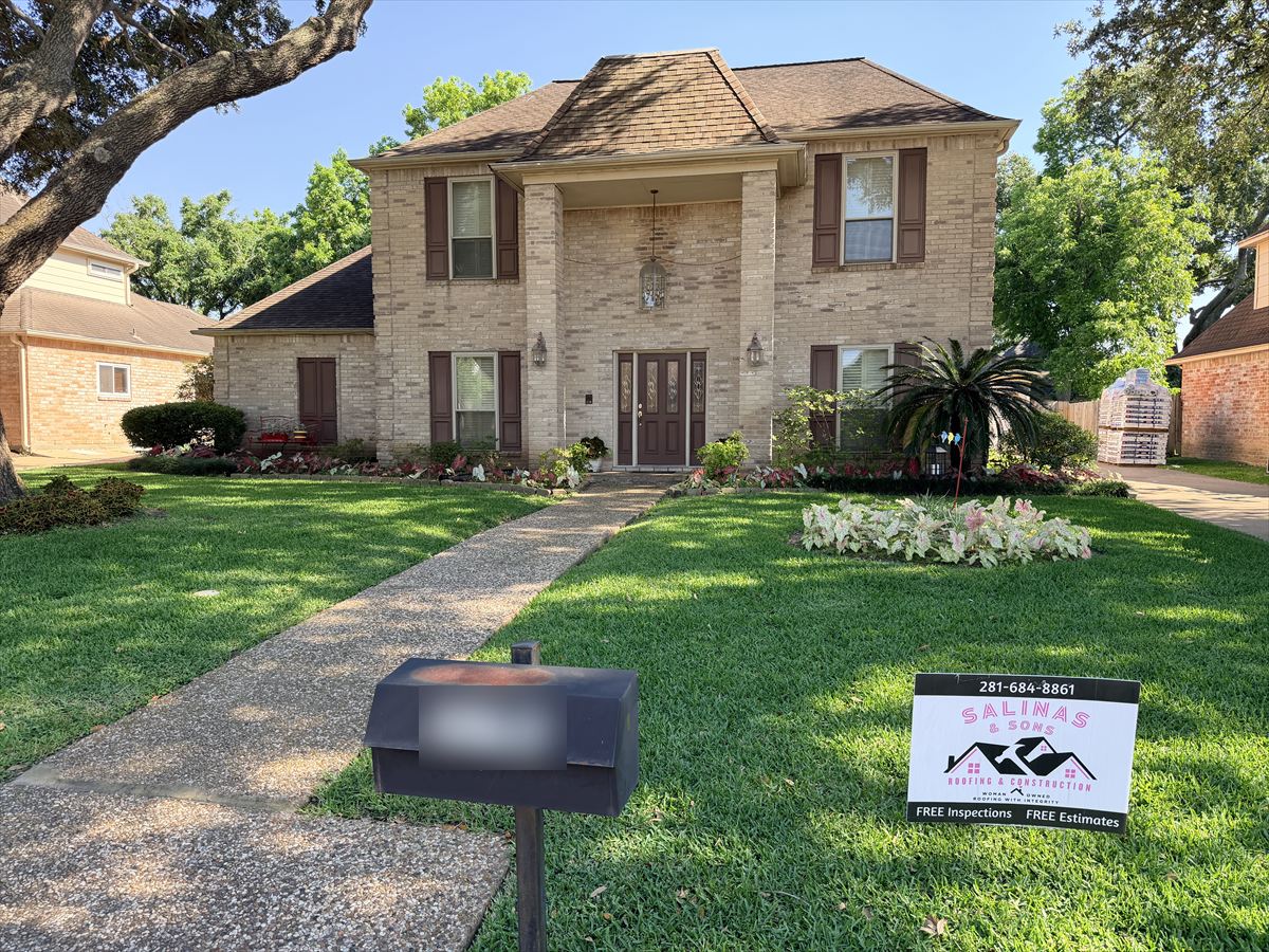 Two-story brick home with its original weathered roof before replacement
