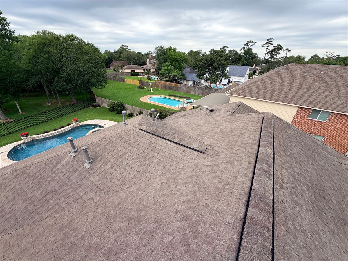 Aerial view of a hail-damaged shingle roof before replacement