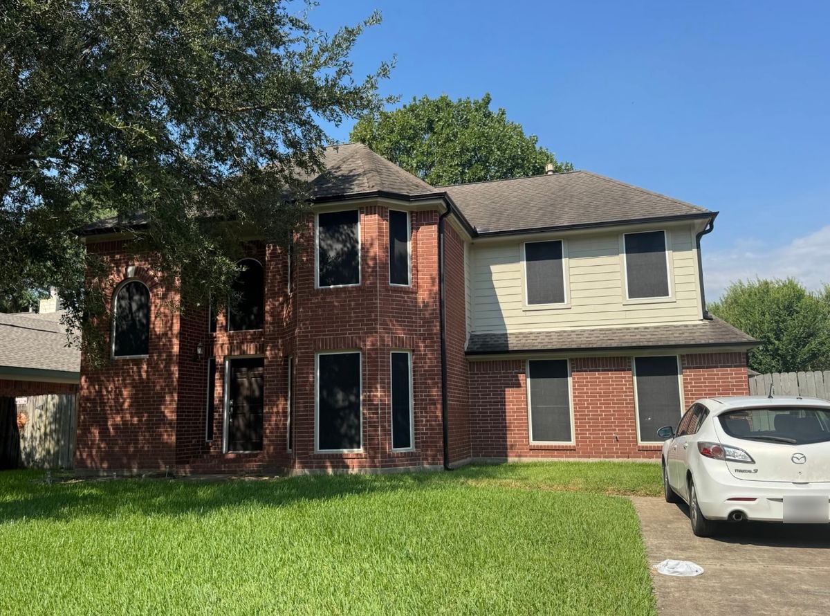 Before: two-story brick home in Pasadena with a faded shingle roof
