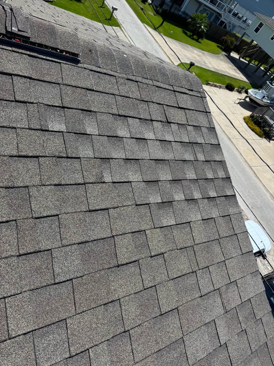 After: the repaired section of the San Leon roof, with new shingles matched to the existing roof along the ridge